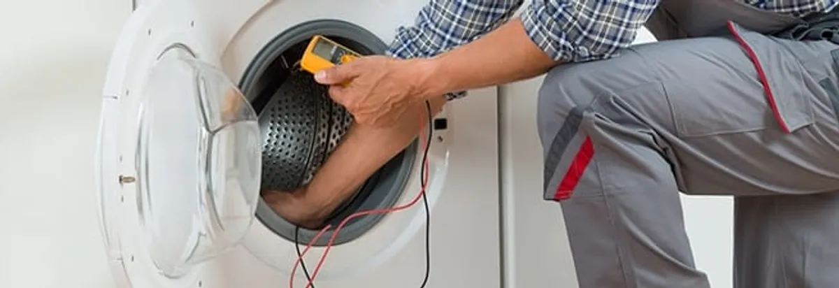 Dryer repair technician inspecting and repairing a clothes dryer in Knoxville, TN