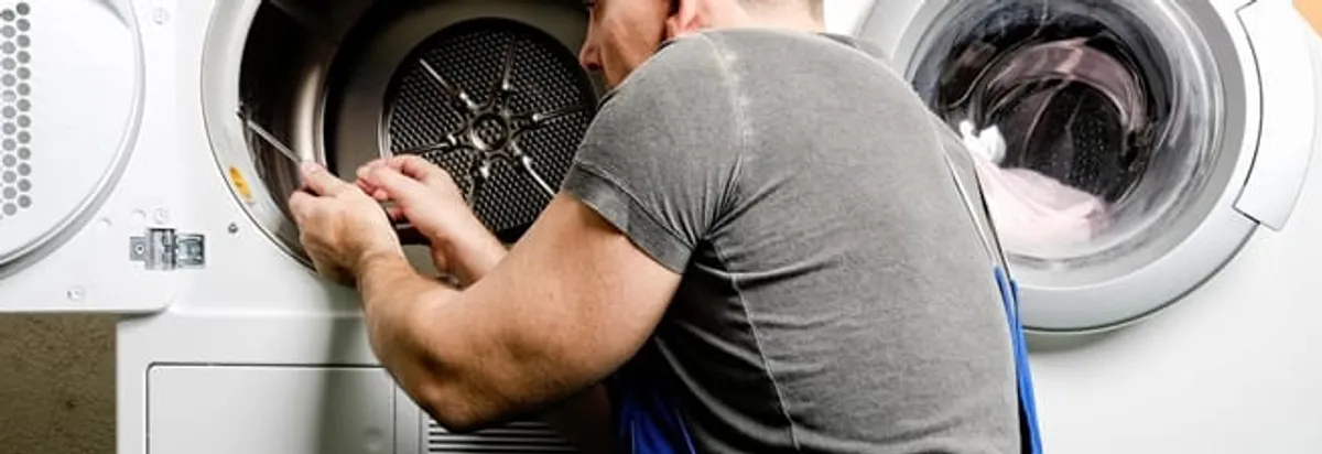 Dryer repair technician fixing a clothes dryer drum in Knoxville, TN
