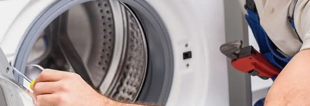 Appliance technician repairing a clothes dryer drum and internal parts in Knoxville, TN