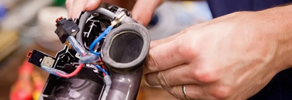 Vacuum repair technician reconnecting wiring and components in Knoxville, TN