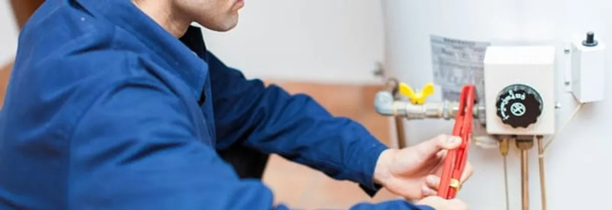 Water heater repair technician adjusting the temperature control and gas valve in Knoxville, TN